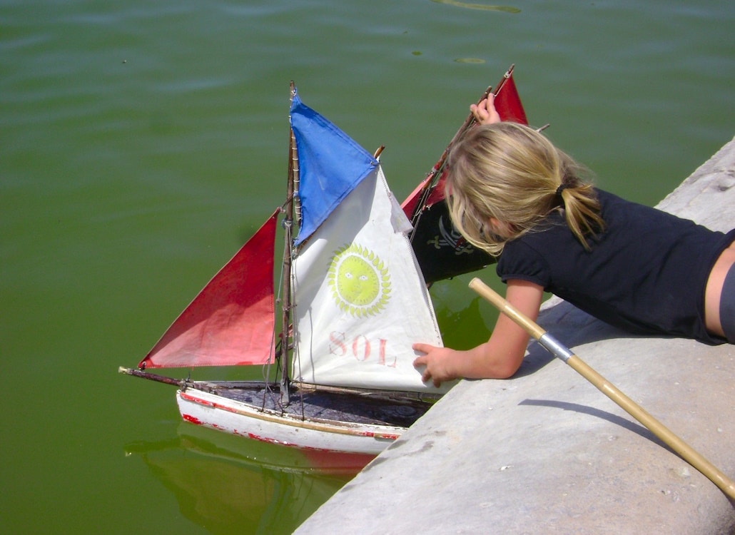kind_zeigt_interesse_am_segeln_segelboot